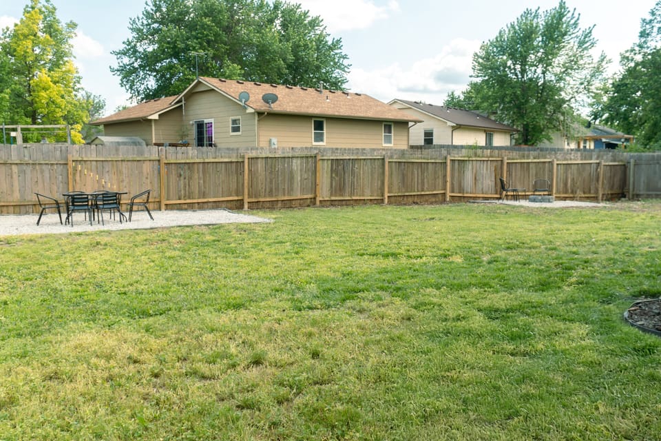 Spacious outdoor living with firepit, patio seating, and room to play.