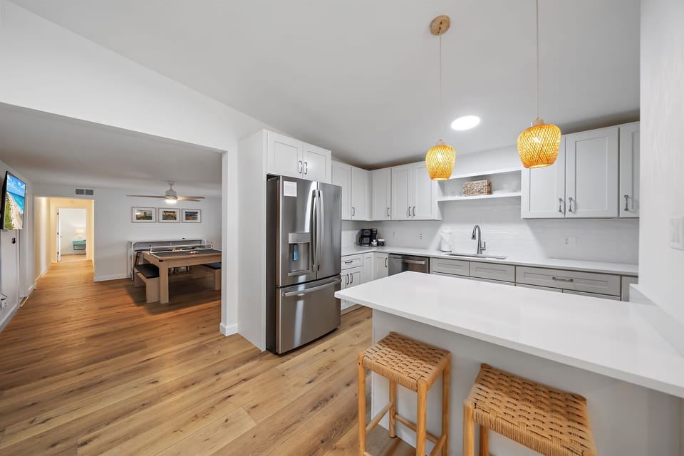 Fully stocked kitchen with new GE stainless steel appliances, a large refrigerator, a modern oven with built-in air fryer, and a deep sink with a retractable faucet— perfect for preparing home-cooked meals!