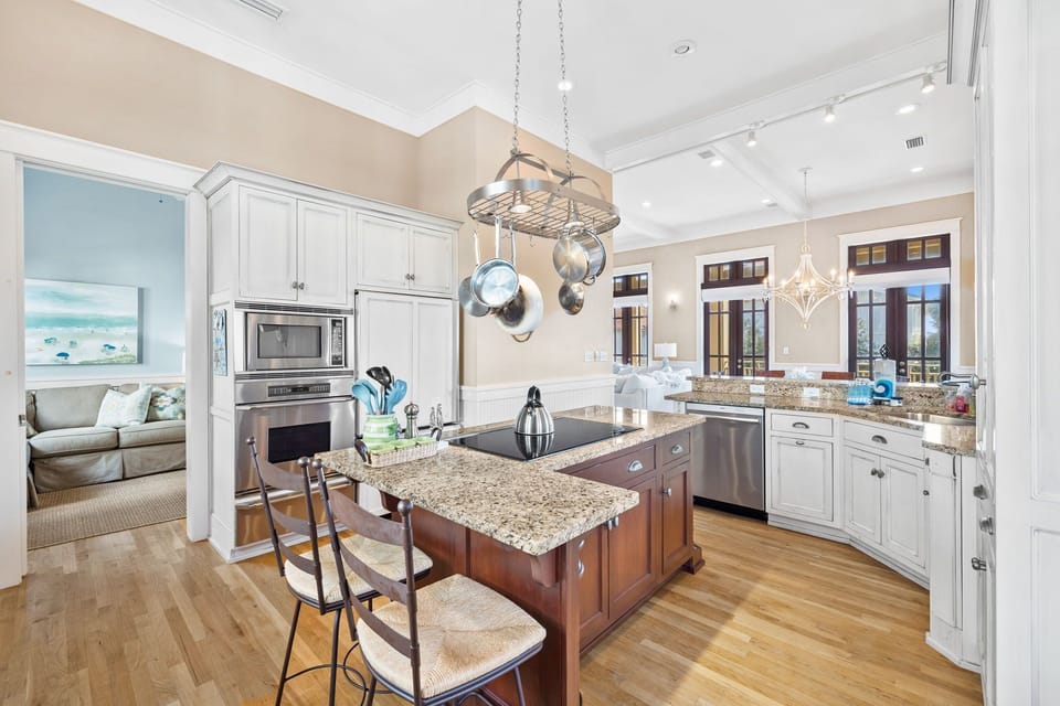Spacious kitchen, island with cooktop, coffee bar, and outdoor grill on balcony.