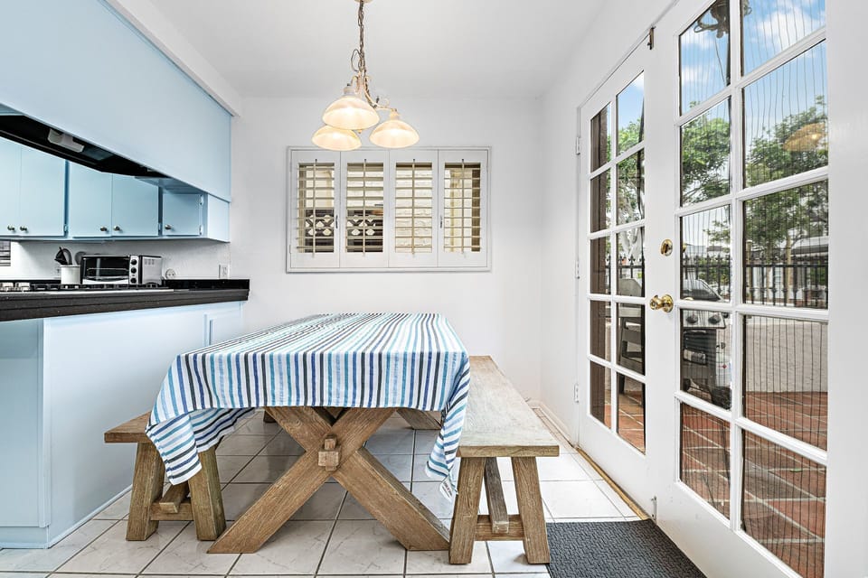Sun-filled and breezy, the breakfast nook opens directly to the front patio through classic French doors
                