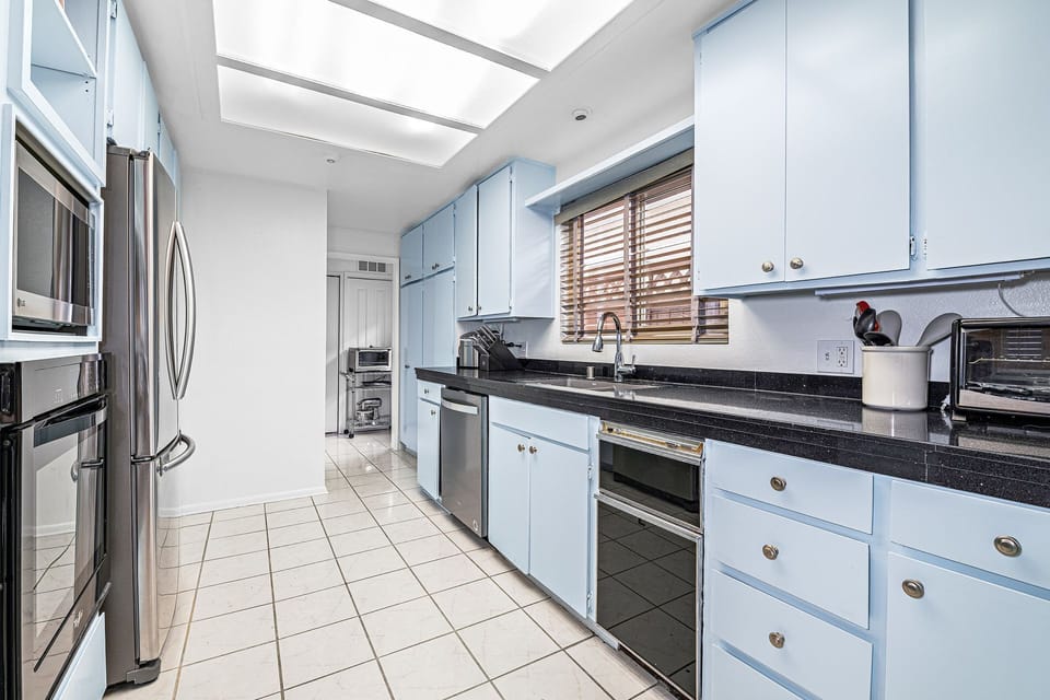The light-filled kitchen features ample counter space and everything needed for easy meal prep during your stay
                
