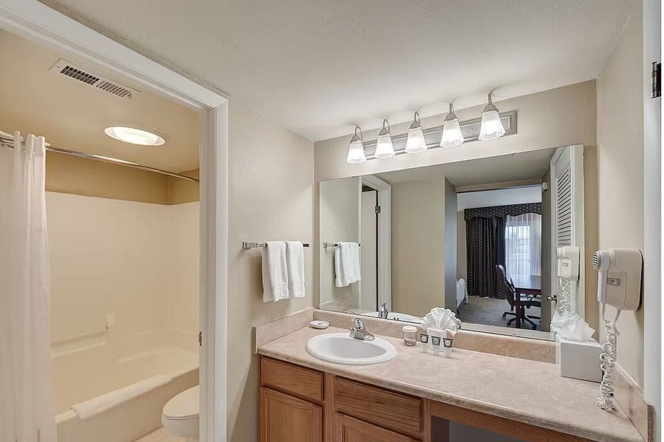 Refresh under bright lights with a spacious vanity setup.