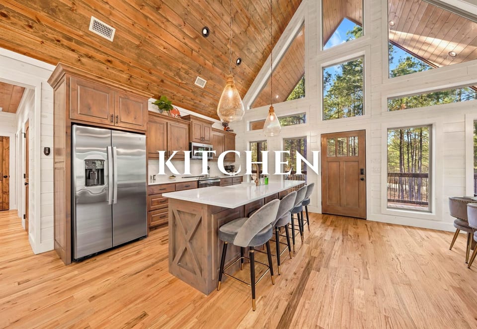 Modern kitchen with stainless appliances and wood finishes.