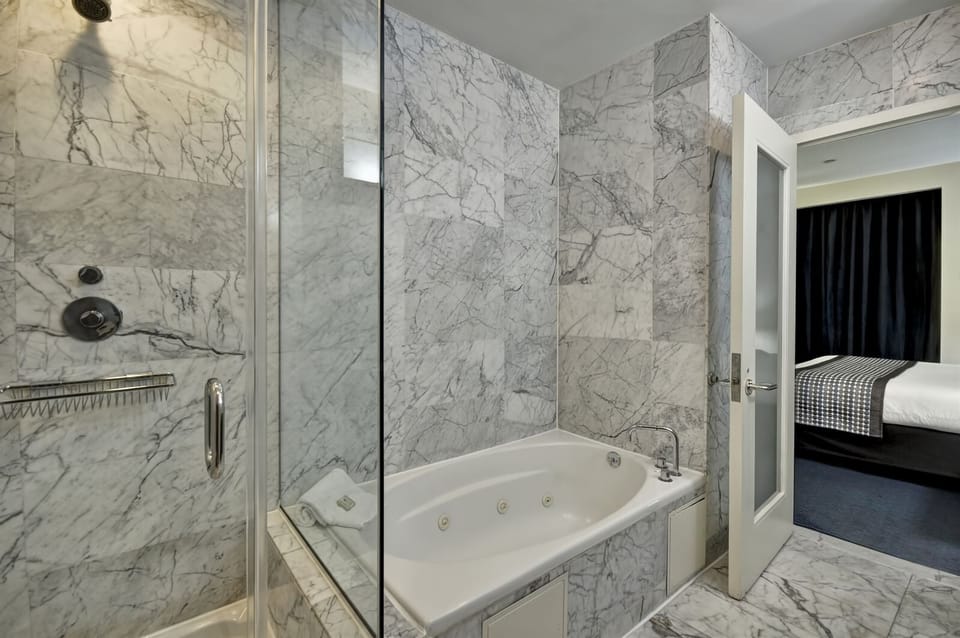 Unwind in a marble bath with deep soaking tub.