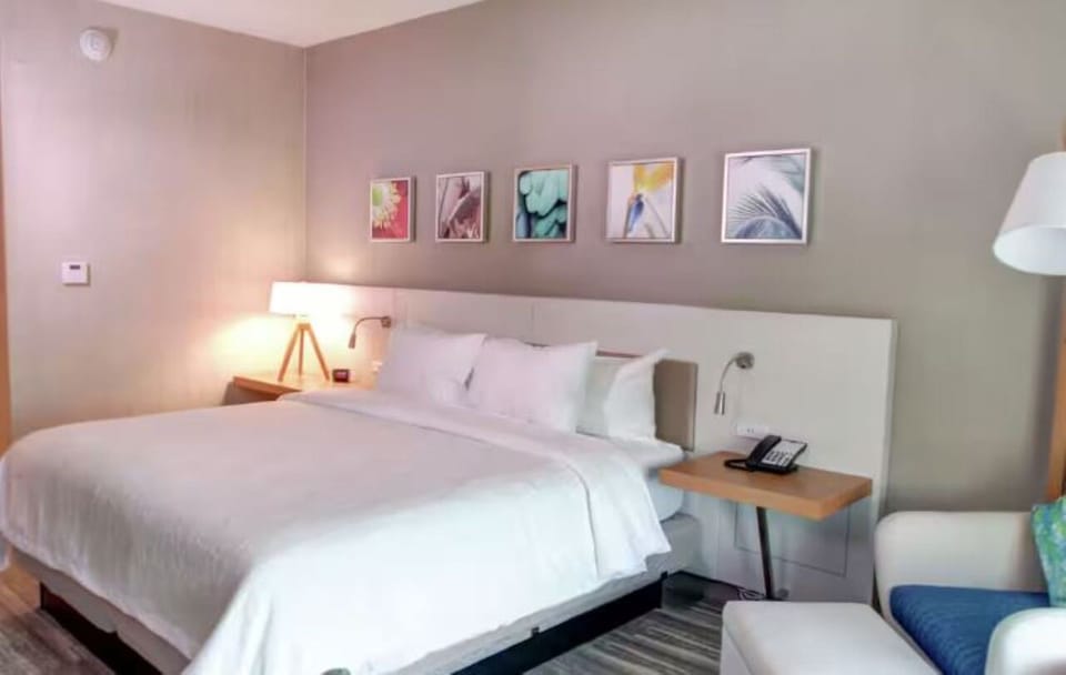 Unwind in crisp linens and a calm, modern bedroom.