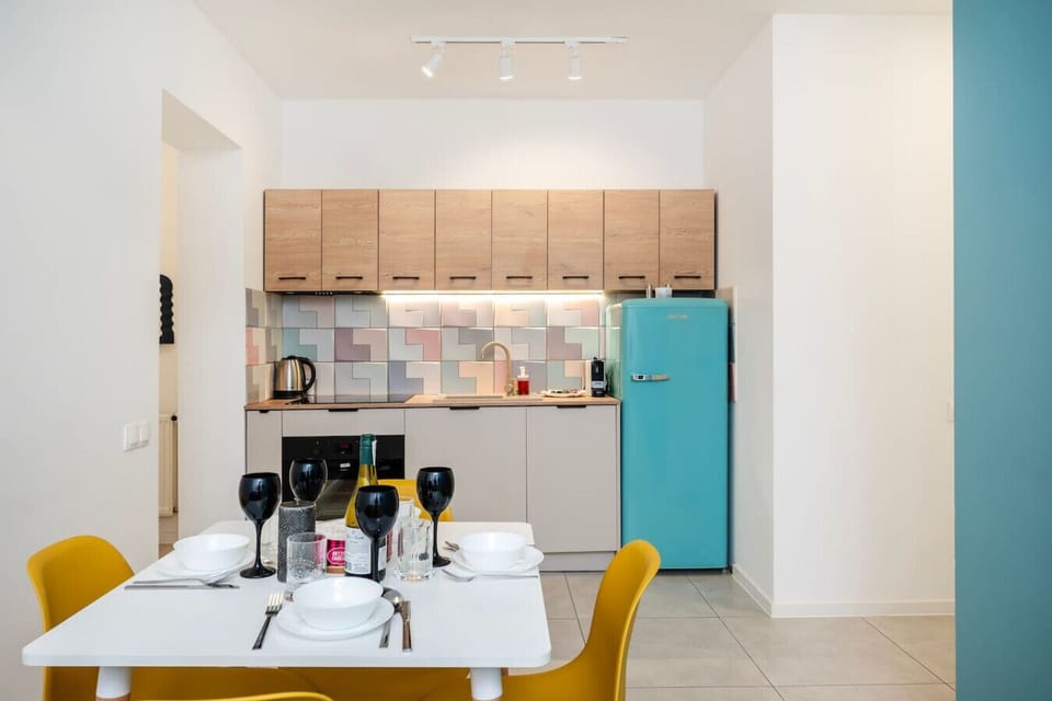 Modern Open-Plan Kitchen and Dining Area with Fully Equipped Kitchen, Retro-Style Fridge and Dining Table for Shared Meals | Book Now with RENTUJEMY.COM