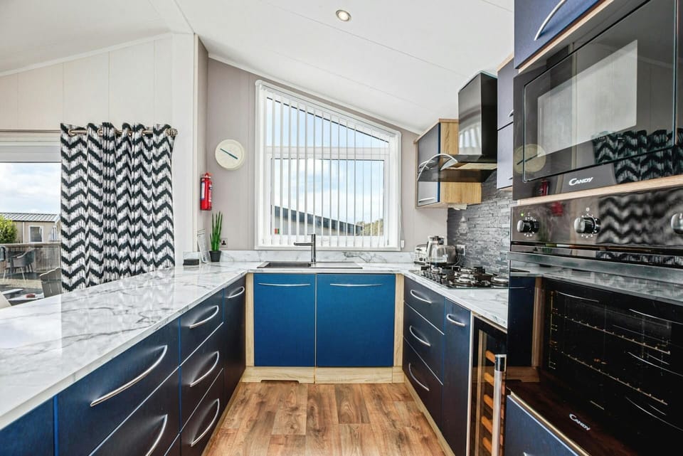 Kitchen with built in oven, microwave, gas hob, sink, window