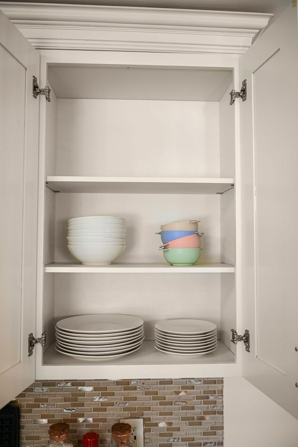 Organized elegance: Clean plates and bowls neatly stored in the kitchen cabinets for your convenience