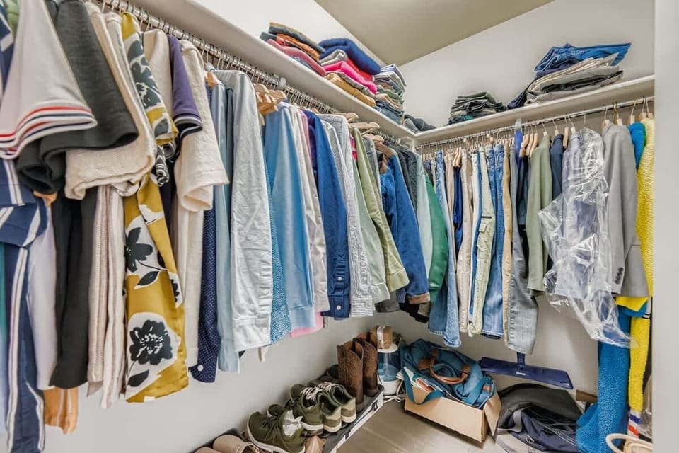This roomy walk-in closet features thoughtful storage options for a neat and convenient experience