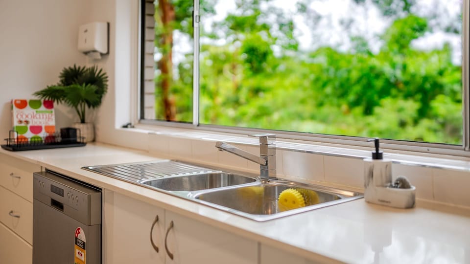 Sunlit sink area with tranquil treetop outlook