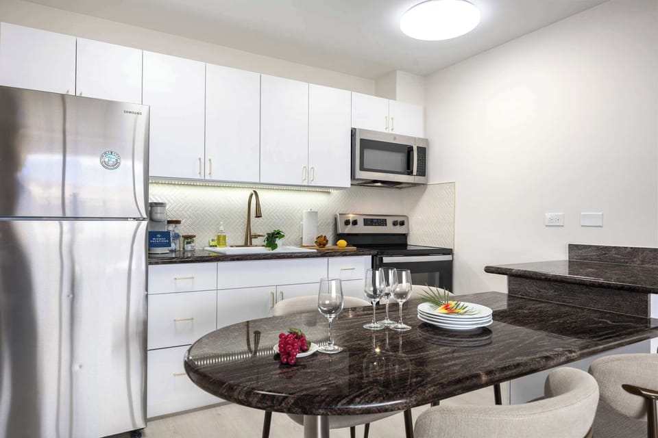 Prepare meals with ease in your sleek, fully equipped modern kitchen featuring stainless steel appliances and a stylish dining bar.