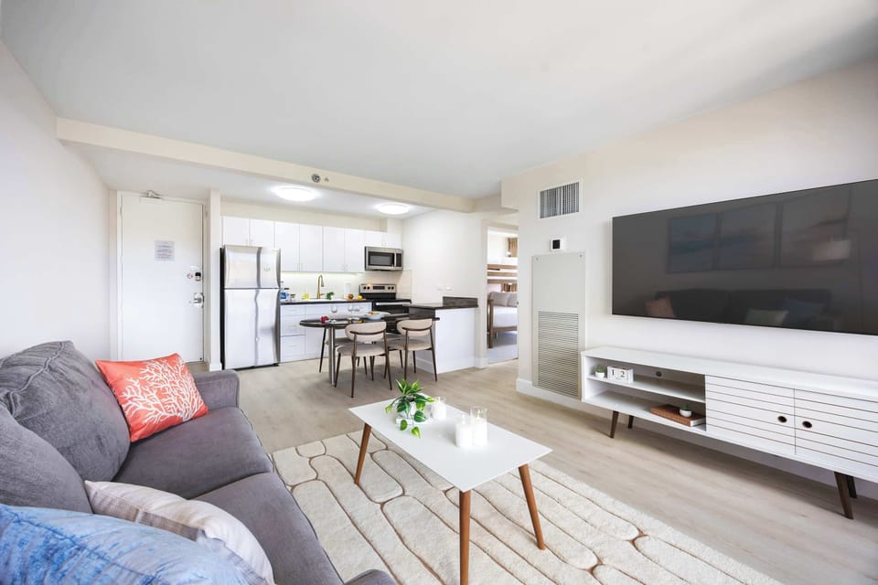Enjoy seamless open-concept living anchored by a spacious lounge with a 65" Smart TV that flows effortlessly into the modern dining and kitchen area.