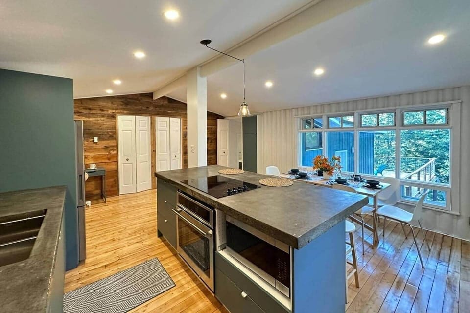 Full sized fridge, oven, stove, and microwave oven. Large concrete countertop.
