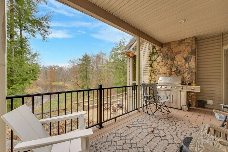 Outdoor dining + BBQ area overlooking the peaceful woods and water