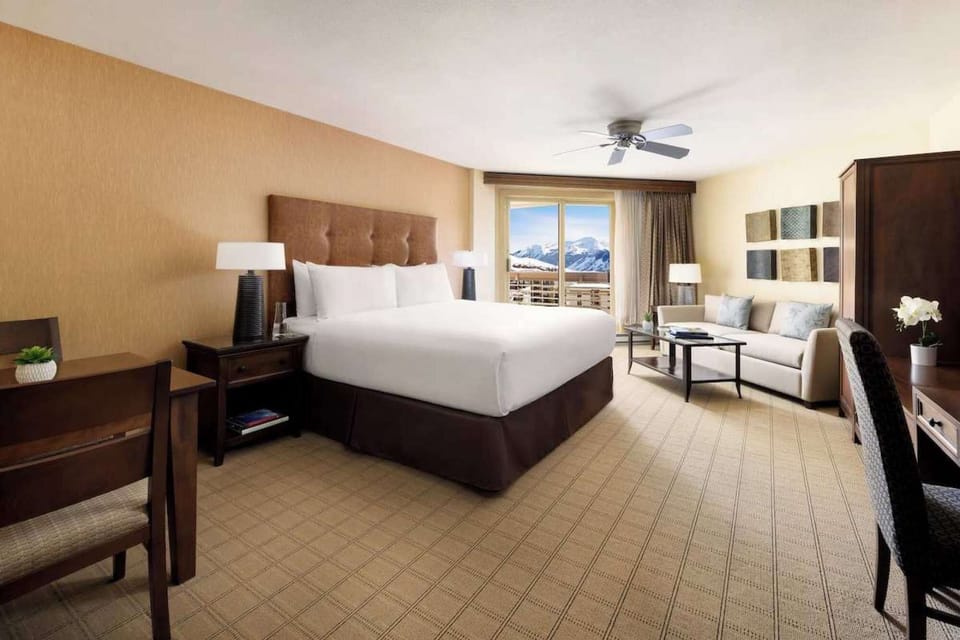 Bright room with king bed, sofa, and scenic views