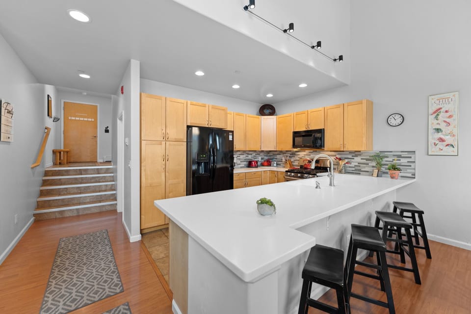 Your spacious kitchen features modern appliances, granite counters, and a breakfast bar perfect for morning coffee or casual dining.