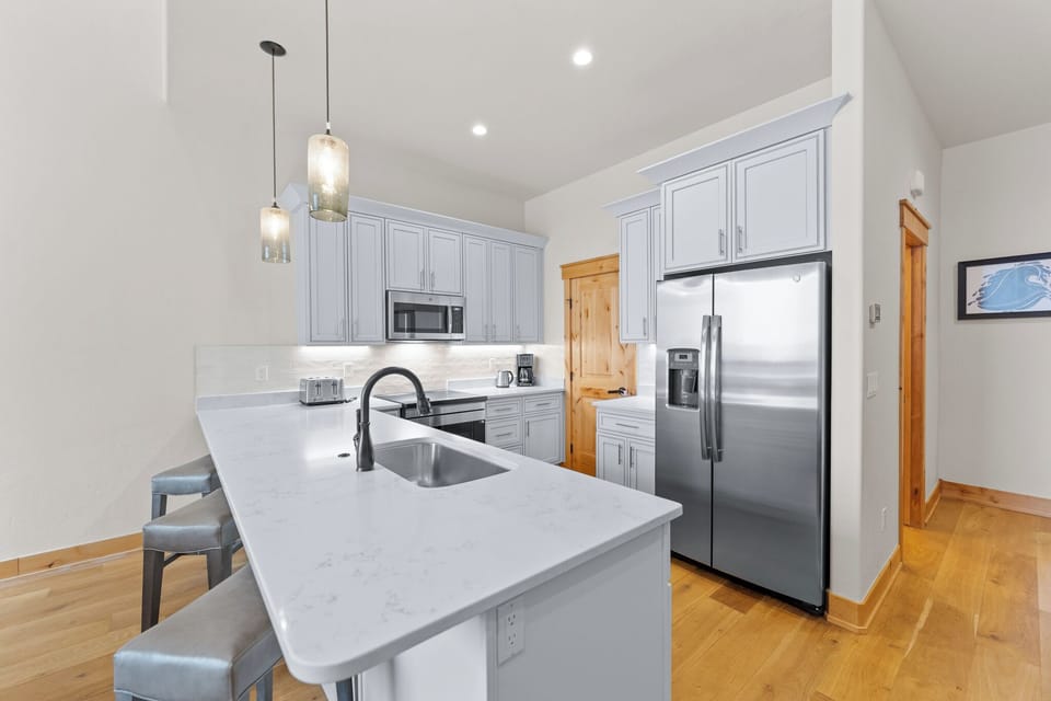 Your fully equipped modern kitchen features marble countertops, stainless steel appliances, and elegant pendant lighting for memorable meals.