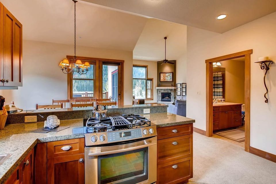 The kitchen's layout allows seamless interaction with guests in the dining area while offering stunning vistas through the nearby windows.