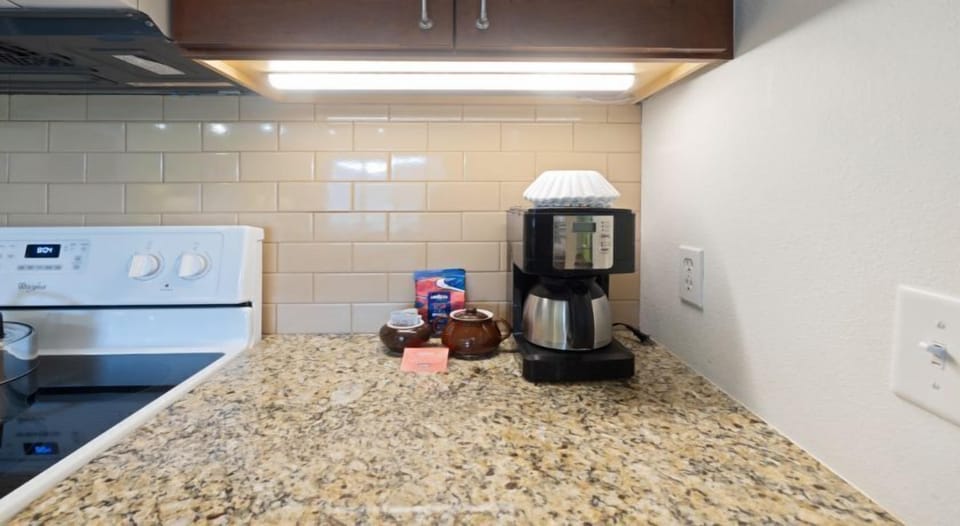 A cozy kitchen nook featuring a coffee maker and granite countertops, perfect for brewing a warm drink before a day in the mountains.