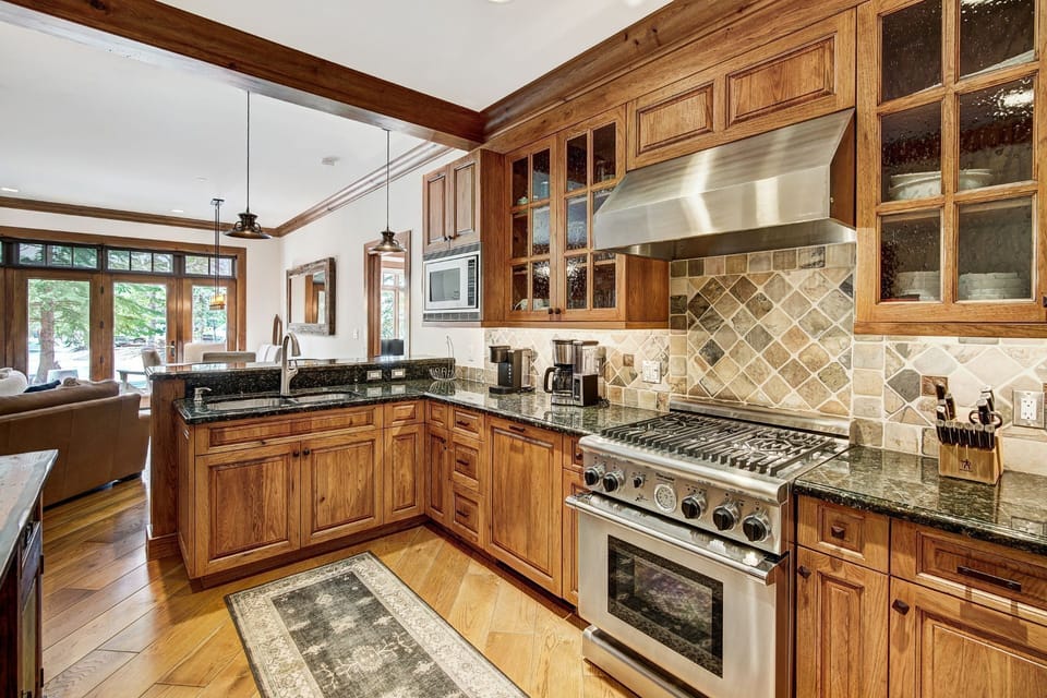 The gourmet kitchen invites culinary inspiration with its polished granite countertops and high-end appliances, ideal for entertaining after a day on the slopes.