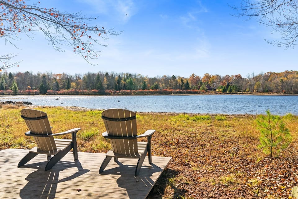 Lakefront relaxation with colorful Adirondack chairs and stunning water views - ideal for morning coffee and sunset watching
