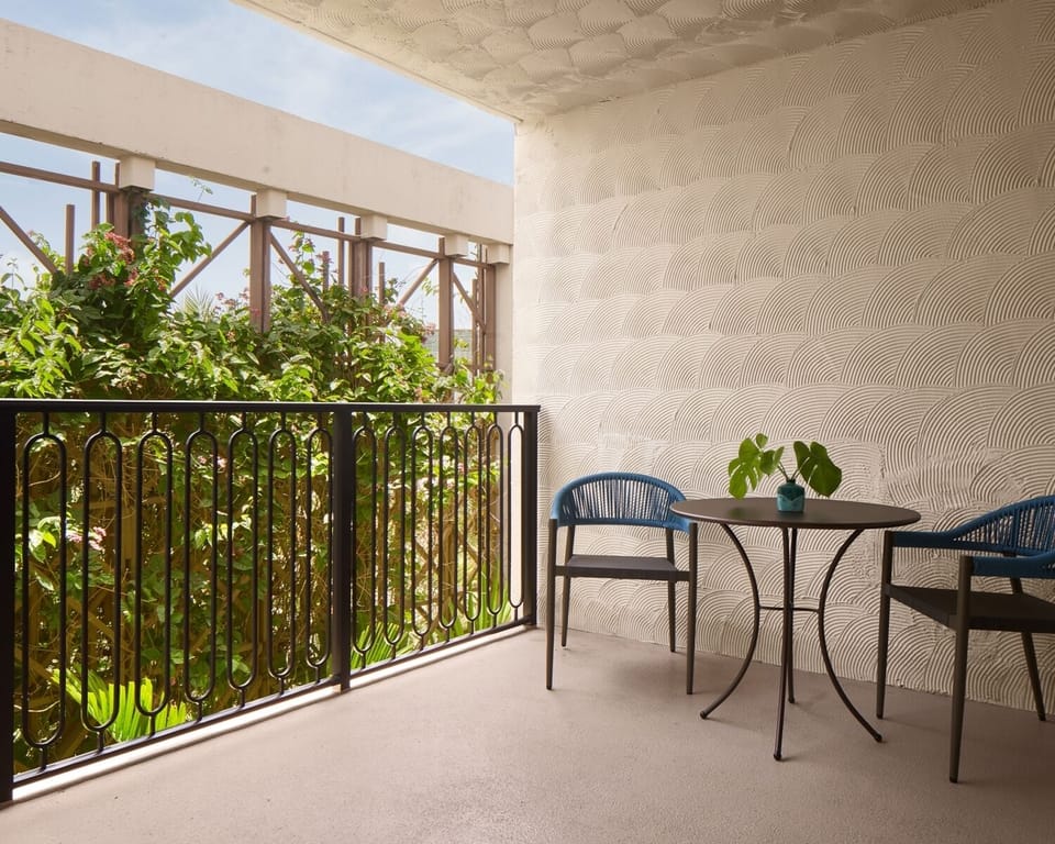 Sip coffee outside on a private balcony wrapped in greenery.