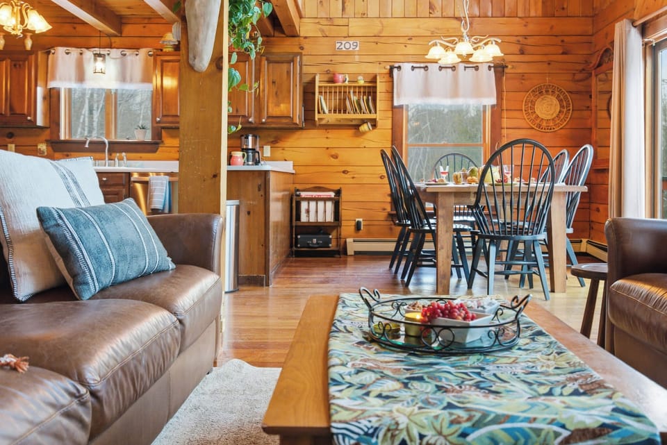 Sitting by the fireplace looking into the dining area and views out to the deck