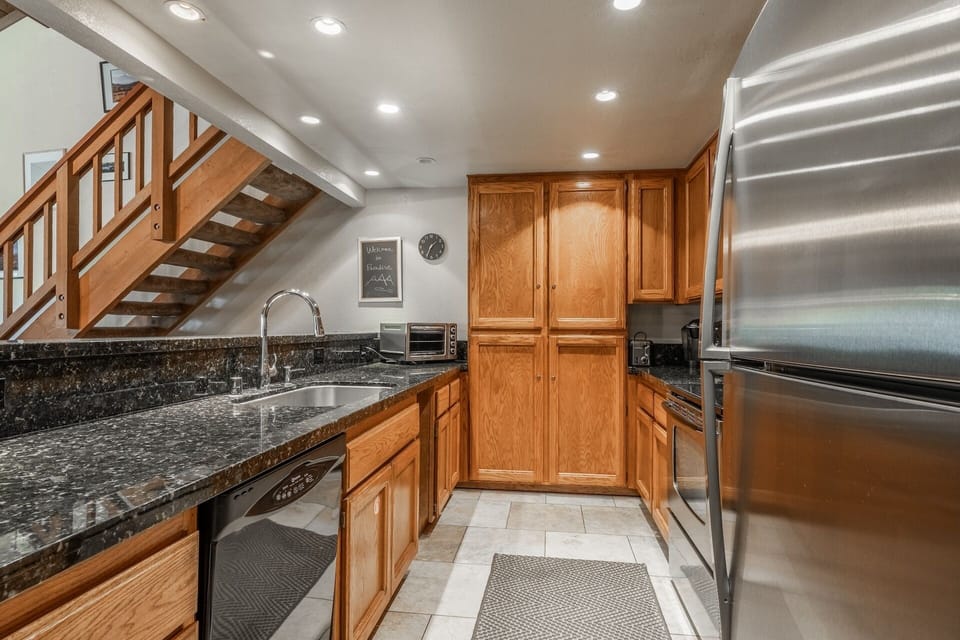Your fully equipped kitchen features granite counters, stainless steel appliances, and warm wood cabinetry—everything you need to prepare meals and feel at home during your stay.