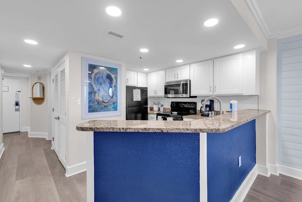 Modern coastal kitchen with full appliances & open-concept design.