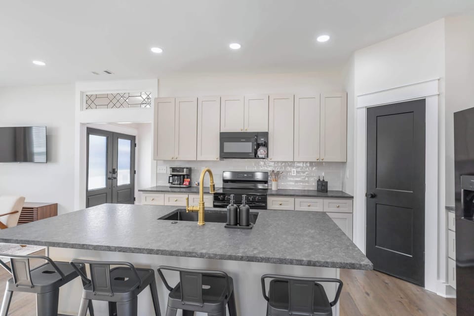 This cozy, light-filled kitchen opens directly to the living room, with a sleek island ideal for morning coffee and quick bites.