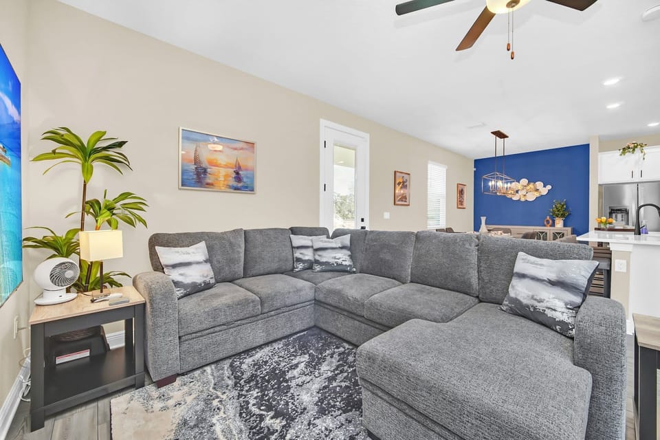 Spacious living room with a large gray sectional sofa and modern coastal decor.