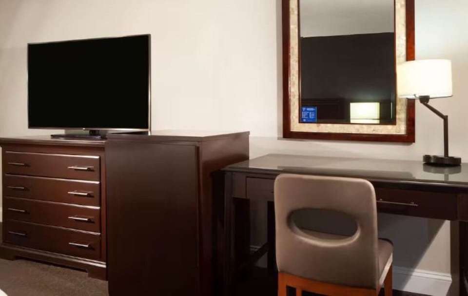 Settle in and stay productive with desk, mirror, and TV.