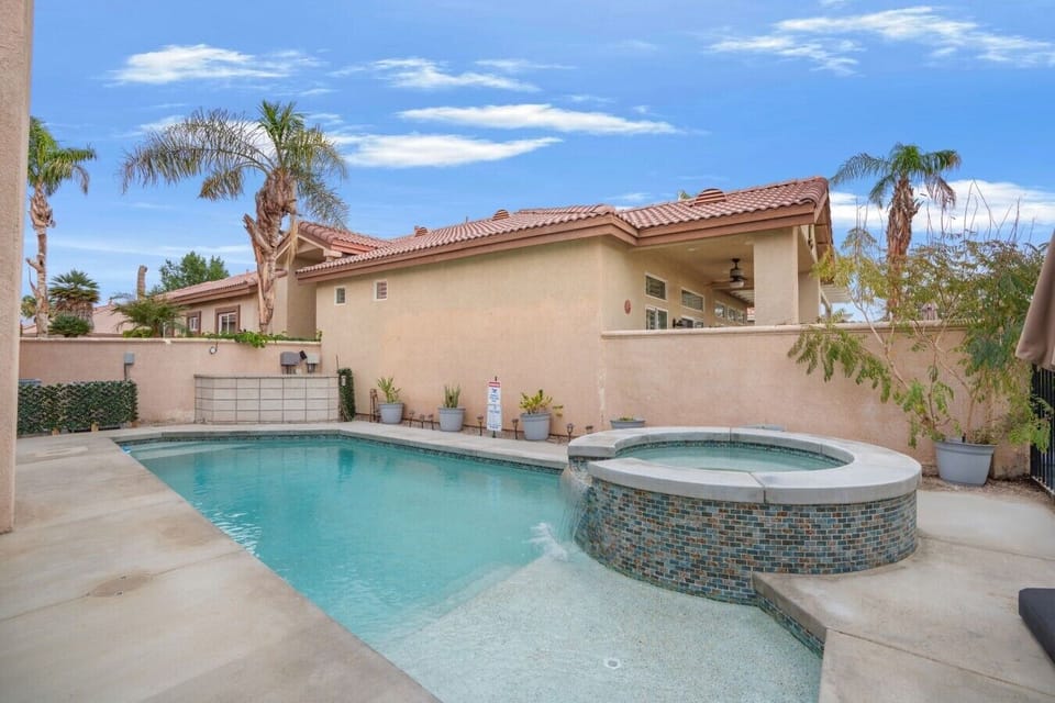 Private backyard pool w/ lounge seating and tall palms creating a relaxed desert escape.