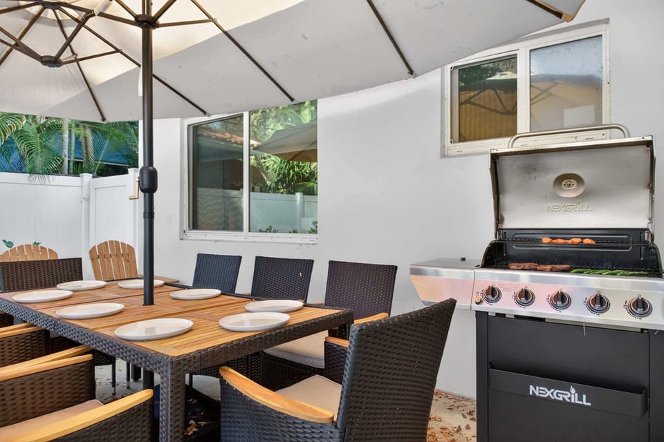 Backyard table situated beside the BBQ grill, creating an easy and enjoyable outdoor dining experience.