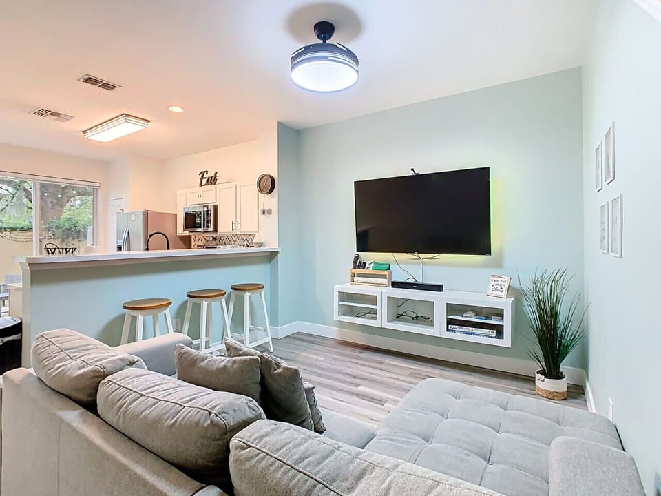 Open living room with bar seating and flat-screen TV.