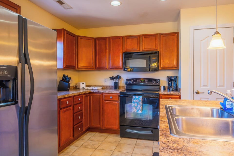 Fully equipped and ready for your culinary creations! This kitchen features rich wood cabinetry, all the necessary appliances, and ample counter space for preparing family meals.