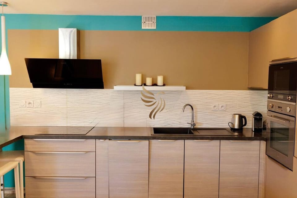 Cuisine moderne et fonctionnelle, nombreux rangements, électroménagers complets et table pour les petits-déjeuners.