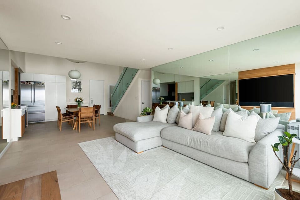 A spacious, meticulously designed living room with plush seating, modern finishes, and sweeping ocean views — bright, airy, and perfect for relaxing or entertainingA spacious, meticulously designed living room with plush seating, modern finishes, and swee