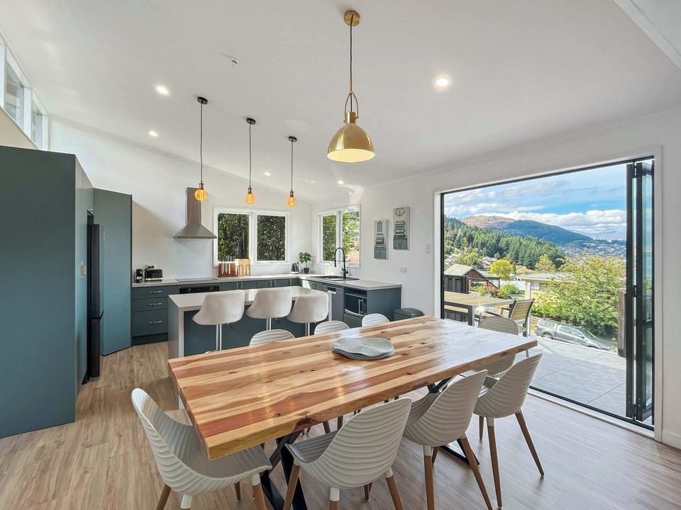 Light-filled open-plan living with a modern kitchen, dining area, and easy access to the balcony