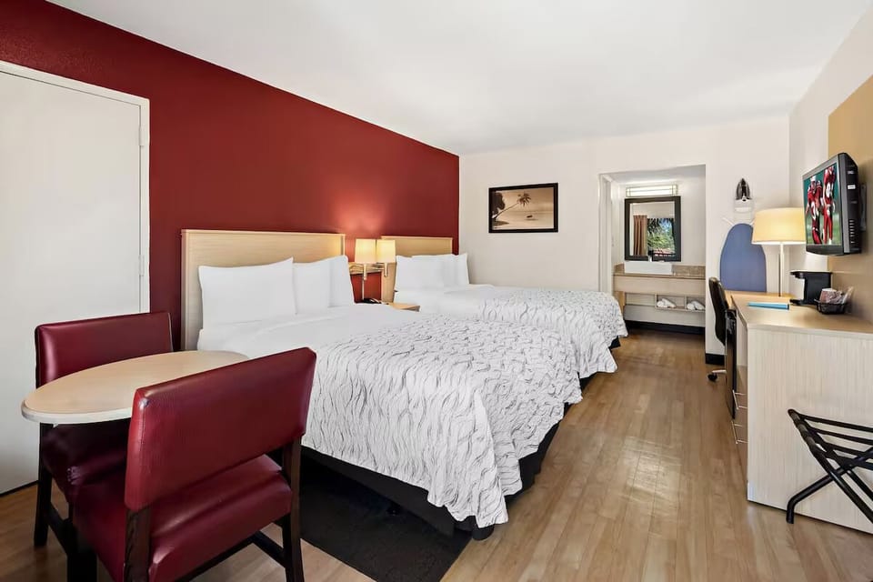 Unwind in a bright double-queen room with cozy seating.