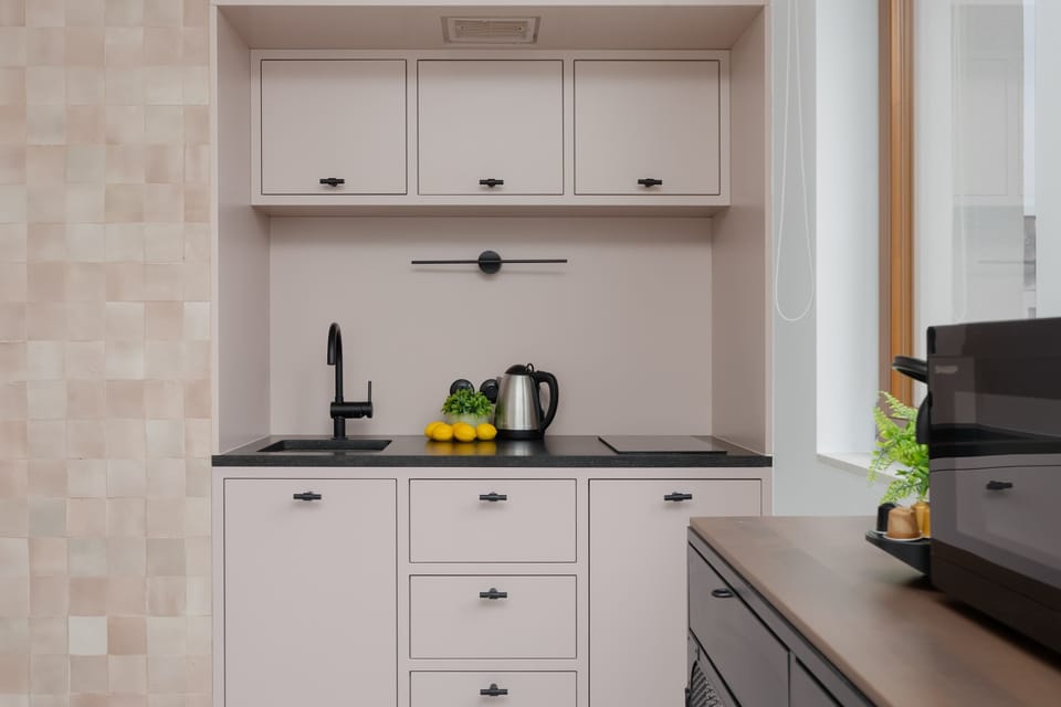 Modern kitchen with light cabinetry and built-in appliances.