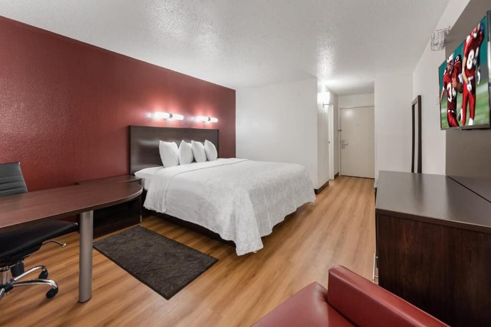 Unwind in a spacious room with desk and plush bedding.