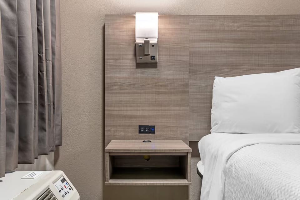 Rest easy with bedside essentials and blackout curtains nearby.