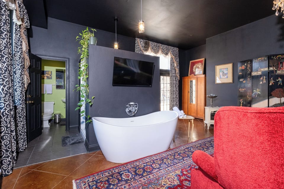 Open-concept layout highlighting the soaking tub, wall-mounted TV, and distinctive design details.
