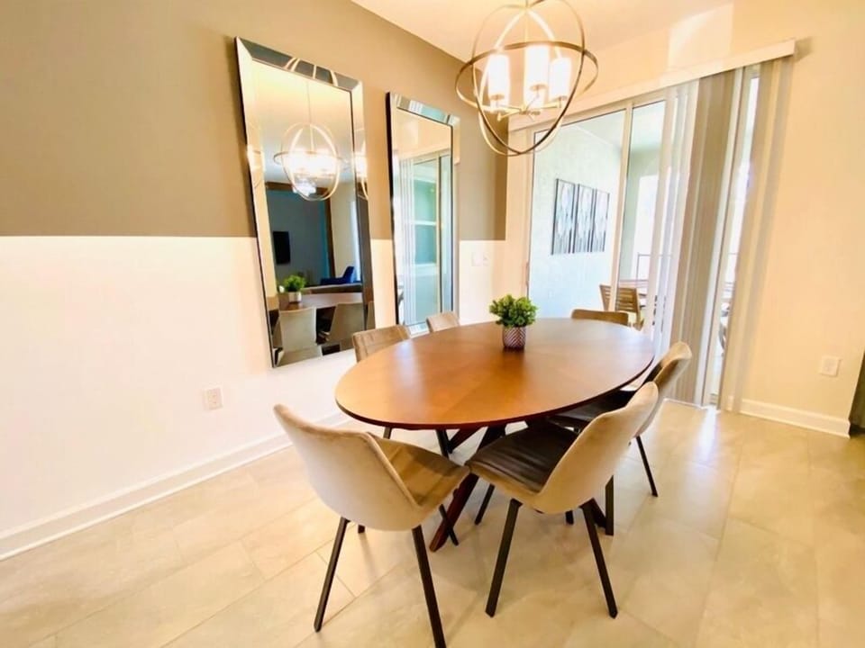 Gather around your elegant dining table where warm conversations flow as naturally as the abundant light streaming through floor-to-ceiling windows.