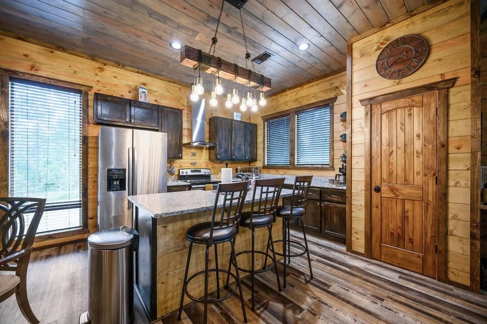Your rustic kitchen awaits with granite counters, stainless appliances, and warm wood details creating the perfect mountain retreat cooking space.