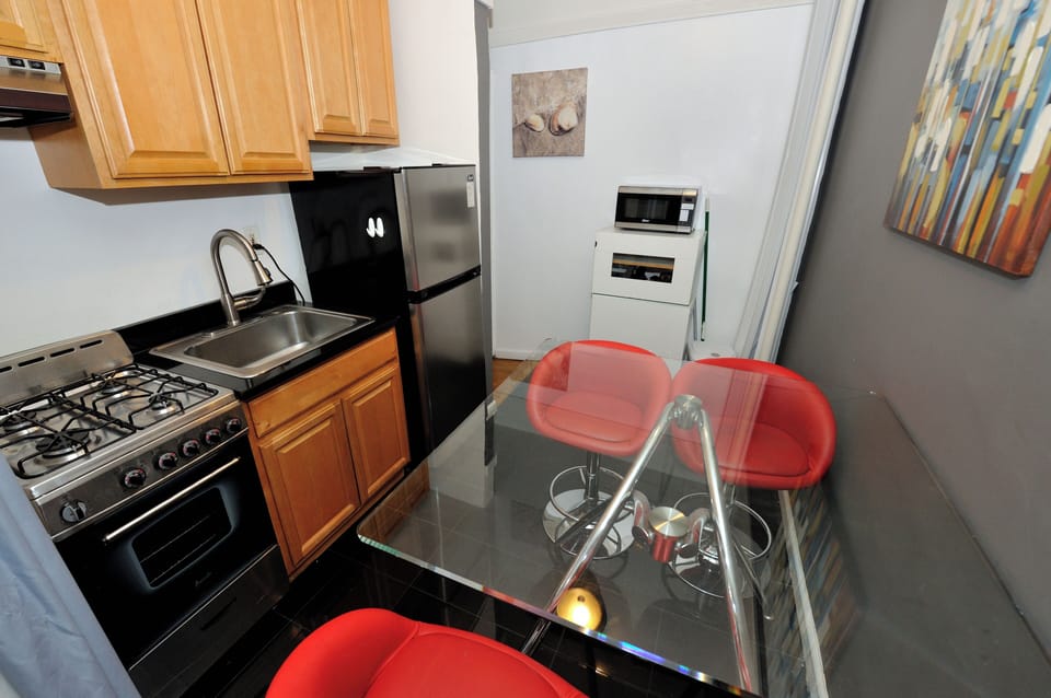 Your sleek kitchen features modern appliances and a glass dining table where you can enjoy meals together in style.