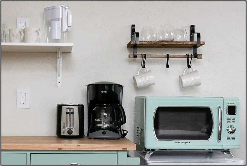 Your fully equipped kitchen awaits with modern appliances, coffee maker, and charming mint-green microwave for easy meal prep.