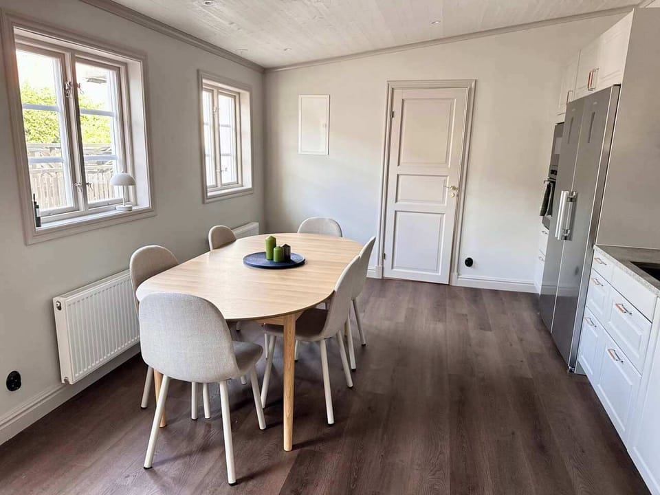 Dining spot for up to 8 guests with large windows facing the terrace. 