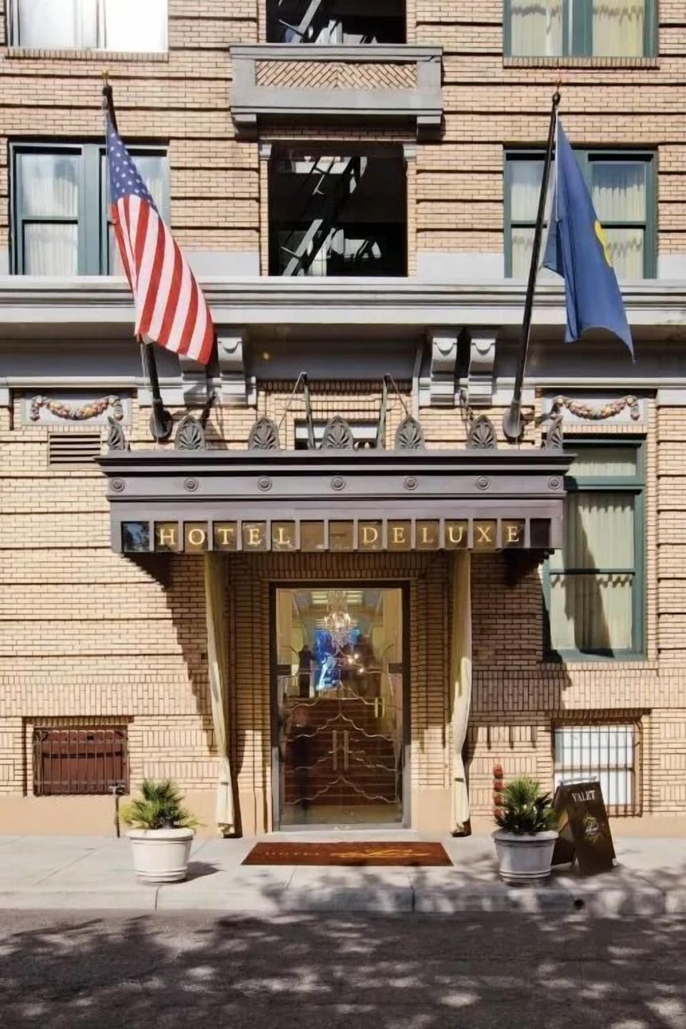 Our hotel's grand entrance, featuring classic architecture and welcoming flags, invites you to a world of elegance and comfort.